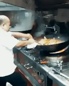 chef wok tossing food in kitchen