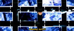 Batman watching surveillance monitors