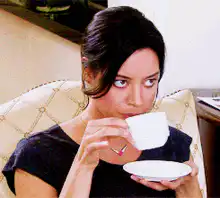 Woman sipping tea with intense stare