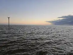 sailboat buoy in ocean at sunset