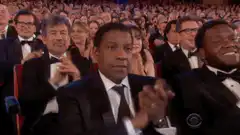 Denzel Washington clapping with a serious face