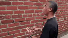 Man doing magic hand tricks against brick wall