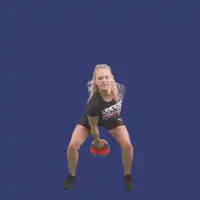 Woman swinging red kettlebell