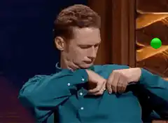Andrew Lincoln checks watch and points