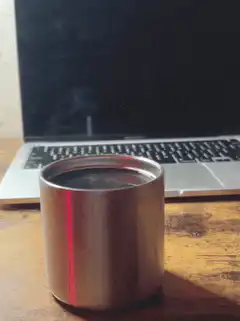 coffee cup in front of laptop