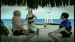 Woman pours drink on man at beach