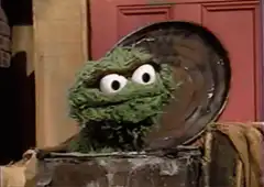 Oscar the Grouch closes his trash can