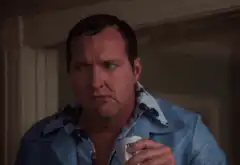 Man in blue shirt sips and frowns