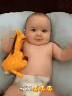 Baby holding giraffe plushie