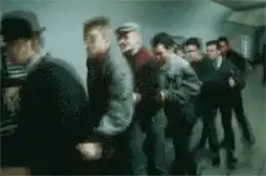 Men in trench coats dancing in a line