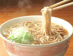 chopsticks lifting steaming noodles