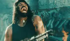Dave Bautista screaming with a gun