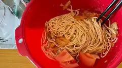 noodles in red bowl with chopsticks