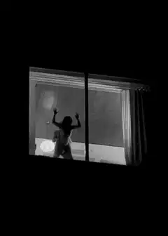 woman dancing in window at night
