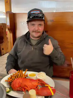 Man gives thumbs up to lobster dinner