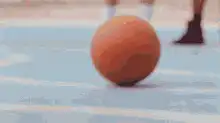 Person picks up basketball and looks at friend