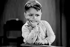 Sad little boy resting chin on hand