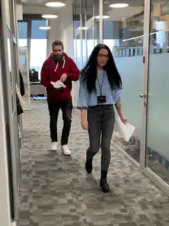 Man sneezes on woman in office hallway