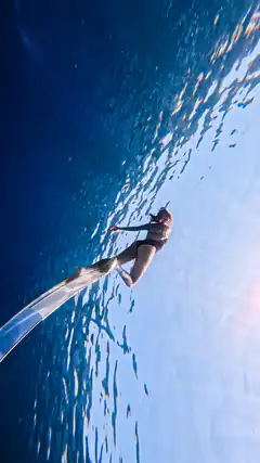 Woman freediving underwater with long fins