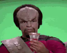 Worf drinks from a glass