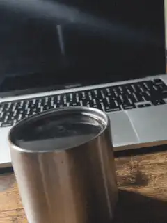 coffee cup in front of laptop