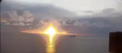 Sunset over ocean with ship