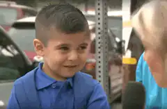 Boy shyly covers face during interview