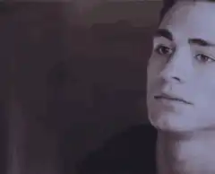 Colton Haynes smirking and looking down