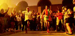 Two women in colorful wigs dancing at a party