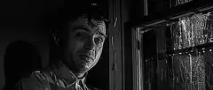 Man looking out rainy window