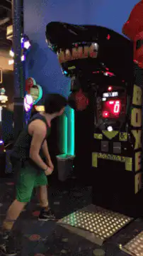 Man punches arcade boxing machine