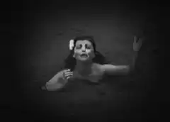 Woman sinking into dark water
