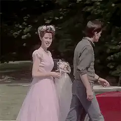 Bride in pink dress waves and smiles