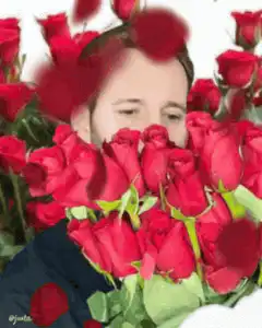 man smelling roses with falling petals