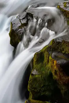 water flowing over mossy rocks