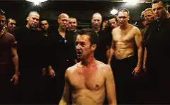 Shirtless man surrounded by crowd