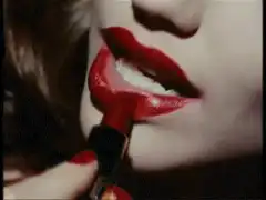 Applying red lipstick close-up