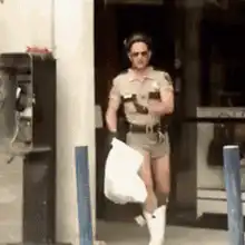 Officer dancing with a white bag