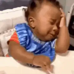 Baby crying with hand on head
