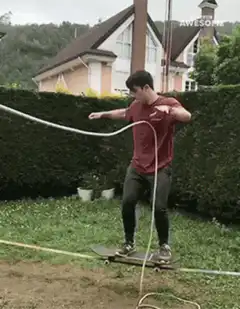 man balancing on skateboard with rope