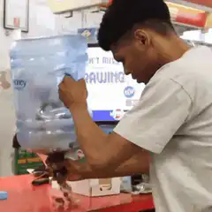 Man shakes water cooler bottle