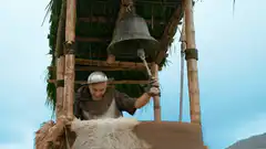 Man hits bell with a stick