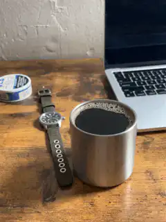 Coffee cup on desk with laptop and watch