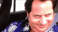 David Schwimmer smirking in a car