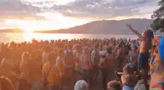 Crowd dancing at sunset beach party