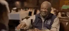 Three friends laughing at dinner table
