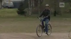 Man on bike waves and smiles