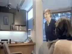 Man jumps over desk in office