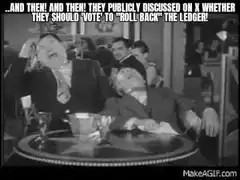 Two men laughing hysterically at a table