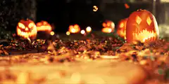 glowing jack o lanterns in leaves
